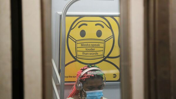 A commuter wears a mask under public safety signage as cases of the infectious coronavirus Delta variant continue to rise in New York City, New York, U.S., July 26, 2021. REUTERS/Andrew Kelly - Sputnik International