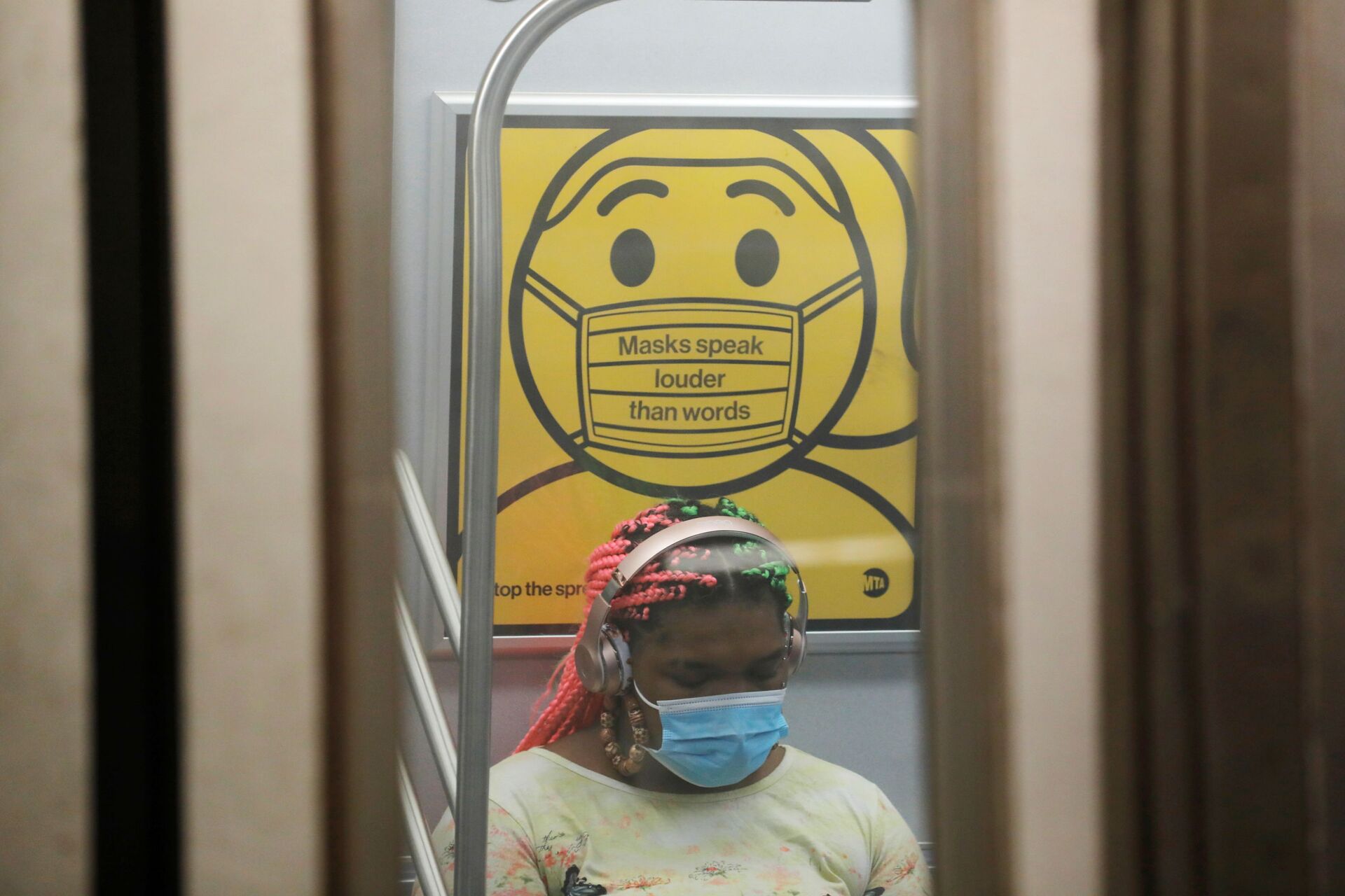 A commuter wears a mask under public safety signage as cases of the infectious coronavirus Delta variant continue to rise in New York City, New York, U.S., July 26, 2021. REUTERS/Andrew Kelly - Sputnik International, 1920, 07.09.2021