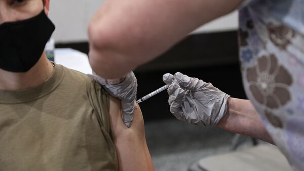U.S. Army Sgt. Brandy Herrmann, assigned to the 24th Theater Public Affairs Support Element, receives the COVID-19 vaccination at Stayton Theater, at Fort Bliss, Texas, Feb. 5, 2021. Herrmann was instructed to wait 15 minutes before driving or participate in vigorous physical activity after receiving the shot. (U.S. Army photo by Pfc. Maxwell Bass, 24th Theater Public Affairs Support Element) - Sputnik International
