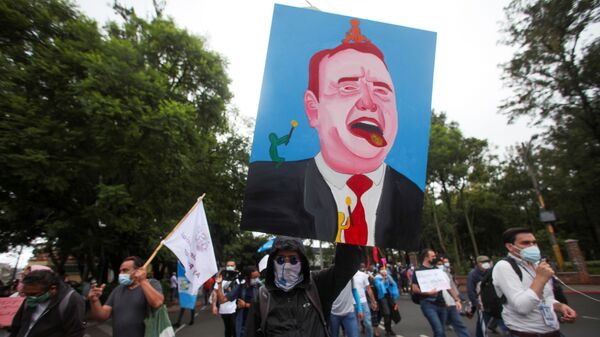 A demonstrator holds up a painting of Guatemalan President Alejandro Giammattei during a protest to demand the resignation of Giammattei and Attorney General Maria Porras, in Guatemala City, Guatemala July 29, 2021 - Sputnik International