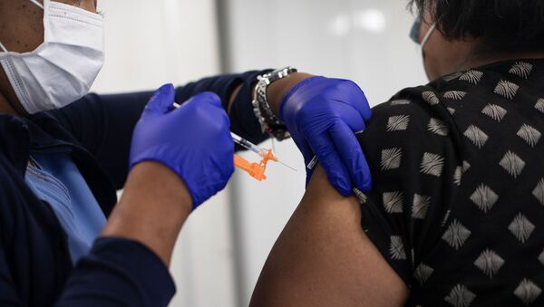 Nurse Angela Norment injects a second dose of the coronavirus disease (COVID-19) vaccine at a mobile pop-up vaccination clinic hosted by the Detroit Health Department with the Detroit Public Schools Community District at Renaissance High School in Detroit, Michigan, U.S., July 26, 2021. - Sputnik International