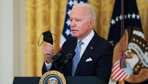 U.S. President Joe Biden holds his mask as he speaks about the pace of coronavirus disease (COVID-19) vaccinations in the United States during remarks in the East Room of the White House in Washington, U.S., July 29, 2021 - Sputnik International