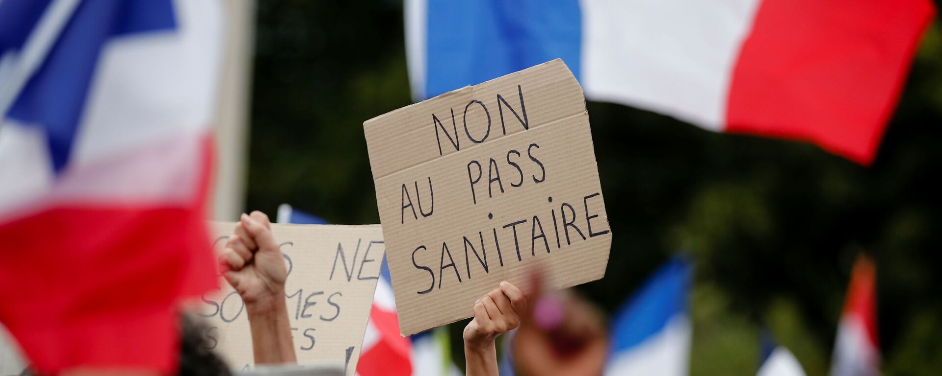 A protester holds a placard that reads No to the health passport during a demonstration called by the French nationalist party Les Patriotes (The Patriots) against France's restrictions to fight the coronavirus disease (COVID-19) outbreak, on the Droits de l'Homme (human rights) esplanade at the Trocadero Square in Paris, France, July 24, 2021. REUTERS/Benoit Tessier - Sputnik International, 1920, 03.10.2021