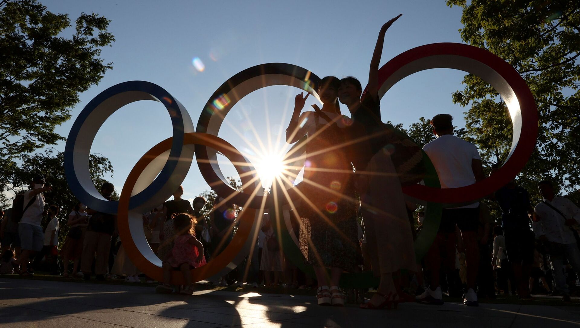 People pose for a photograph in front of an Olympic rings monument outside the National Stadium, the main stadium of Tokyo 2020 Olympic and Paralympic Games, amid the coronavirus disease (COVID-19) pandemic, in Tokyo, Japan July 31, 2021.  REUTERS/Issei Kato - Sputnik International, 1920, 05.09.2021
