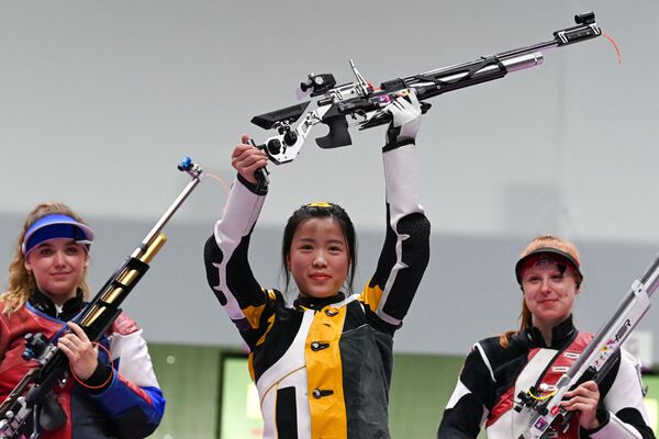 China's Yang Qian celebrates on the podium between Russia's Anastasiia Galashina (L) and Switzerland's Nina Christen after winning the women's 10m air rifle final. - Sputnik International