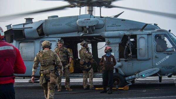 In this photo provided by the U.S. Navy, sailors assigned to an explosive ordnance unit board an MH-60S Seahawk helicopter on the flight deck of aircraft carrier USS Ronald Reagan to head to an oil tanker that was attacked off the coast of Oman in the Arabian Sea on Friday, July 30, 2021.  - Sputnik International