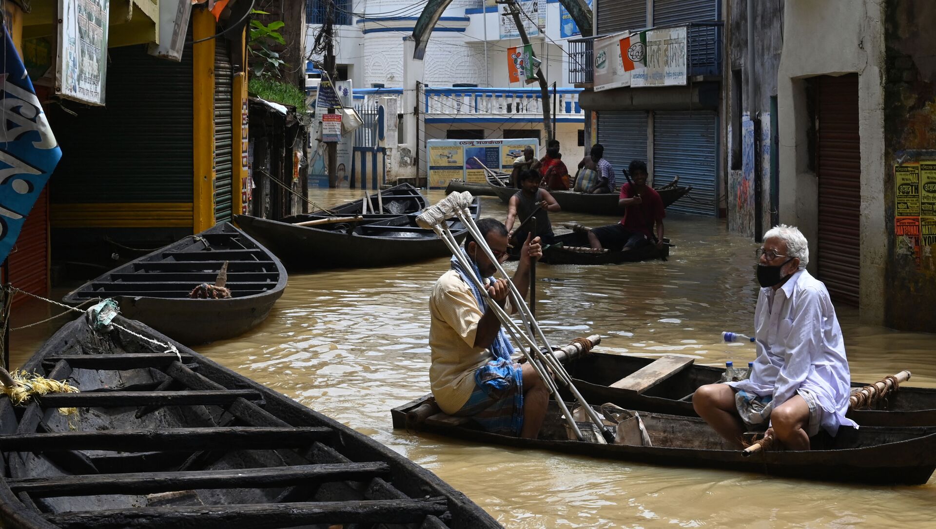 Residents ride a boat over a road submerged by floodwaters following heavy monsoon rains in Ghatal, Paschim Medinipur district, about 100 km from Kolkata on August 2, 2021.  - Sputnik International, 1920, 03.08.2021