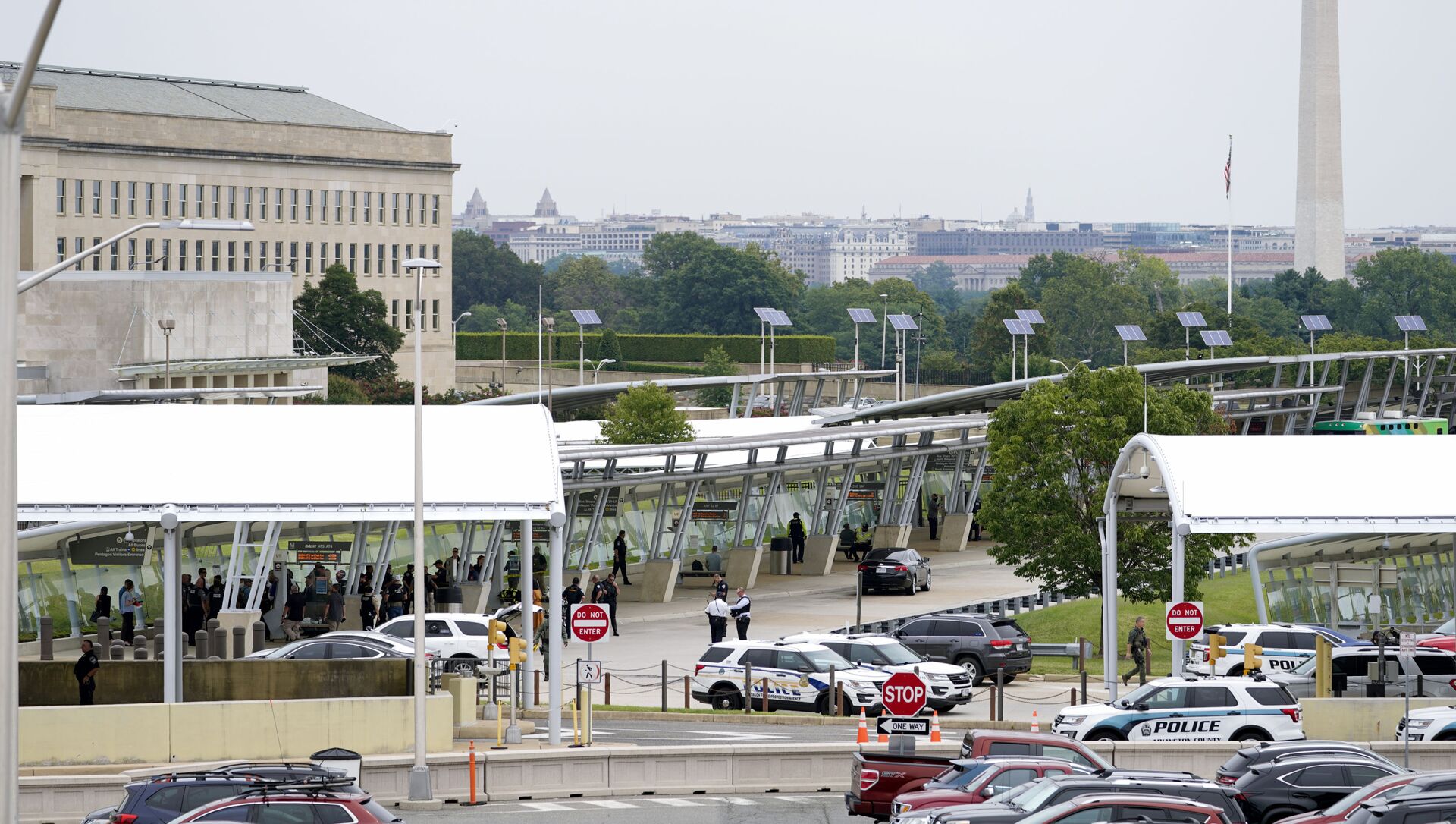 With the Washington Monument in the background, police vehicles are seen outside the Pentagon Metro area Tuesday, Aug. 3, 2021, at the Pentagon in Washington. The Pentagon is on lockdown after multiple gunshots were fired near a platform by the facility's Metro station. - Sputnik International, 1920, 03.08.2021