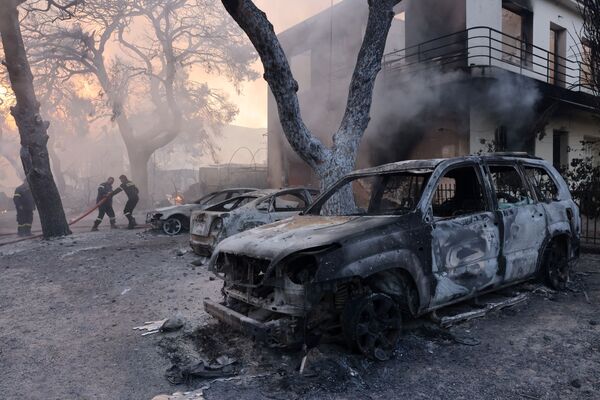 Firefighters work near burnt cars as a wildfire burns in Varympompi, a suburb north of Athens, Greece, 3 August 2021.  - Sputnik International