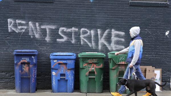 A pedestrian walks past graffiti that reads Rent Strike Wednesday, April 1, 2020, in Seattle's Capitol Hill neighborhood.  - Sputnik International