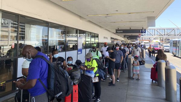 Passengers line up outside the Spirit Airlines terminal at Los Angeles International Airport in Los Angeles on Tuesday, Aug. 3, 2021. Spirit Airlines canceled more than half its schedule Tuesday, and American Airlines struggled to recover from weekend storms at its Texas home, stranding thousands of passengers at the height of the summer travel season. - Sputnik International