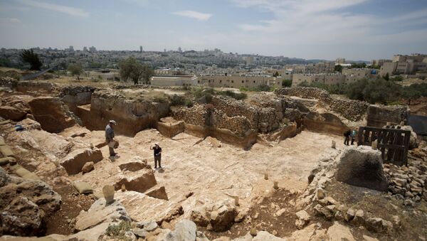 Israeli Antiquities Authority archaeologists work at the excavation site of a 2,000-year-old stone quarry dating back to the Second Temple period discovered in Jerusalem on May 8, 2013 before the construction of a new road in the northern part of city. - Sputnik International