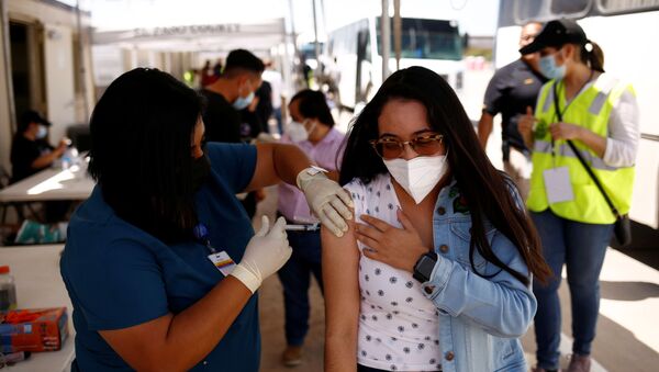 A Mexican woman receives a dose of the Johnson & Johnson coronavirus disease (COVID-19) vaccine, during a binational vaccination program, at the Tornillo-Guadalupe international bridge, in Tornillo, Texas, U.S., July 28, 2021 - Sputnik International