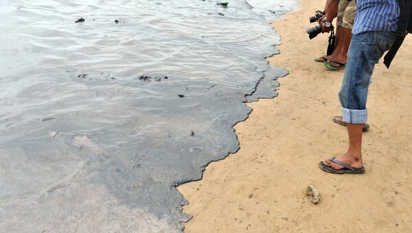 Photographers take pictures of oil contaminated water on the shores of Juhu Chowpatty beach in Mumbai on August 7, 2011.  - Sputnik International