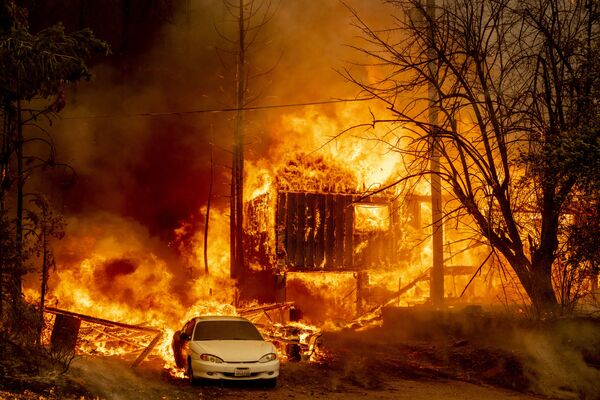 A home is engulfed in flames as the Dixie fire rages on in Greenville, California on 5 August 2021. The largest wildfire in California has razed a small town, warping street lights and destroying historic buildings hours after residents were ordered to flee. - Sputnik International