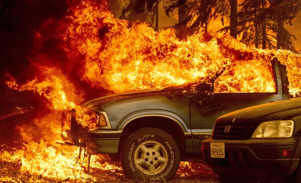 Vehicles and a home are engulfed in flames as the Dixie fire rages on in Greenville, California on 5 August 2021. - Sputnik International