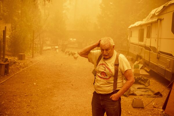 Resident Jon Cappleman prepares to defend his home during the Dixie fire in Twain, California on 24 July 2021. Even as dense smoke from an enormous wildfire blows closer to Jon Cappleman's home in rural northern California, the 60-something man rebuffs calls to evacuate.  A lot of people think we're foolish, he says. But if it comes down to it, Cappleman has a plan: he will fight the flames of the Dixie fire himself. - Sputnik International