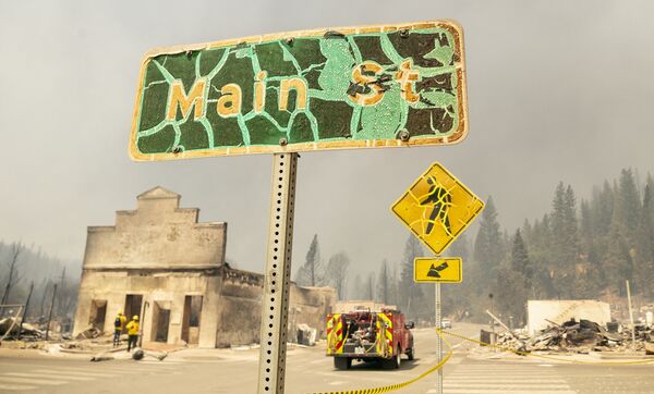A fire-damaged street sign marks Main Street in the decimated downtown of Greenville, California during the Dixie fire on 5 August 2021. - Sputnik International