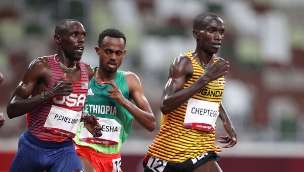 Tokyo 2020 Olympics - Athletics - Men's 5000m - Final - Olympic Stadium, Tokyo, Japan - August 6, 2021. Joshua Cheptegei of Uganda, Paul Chelimo of the United States, and Milkesa Mengesha of Ethiopia during the race. - Sputnik International