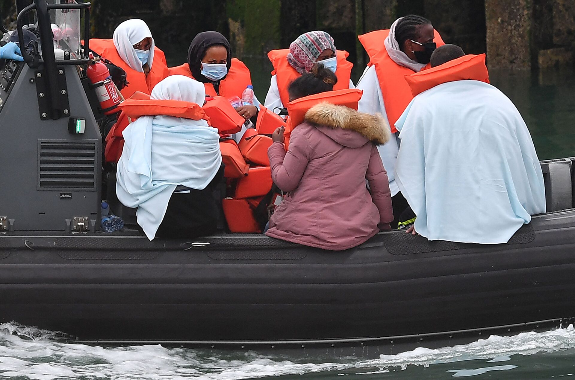 Migrants picked up at sea whilst Crossing the English Channel, but intercepted but intercepted bu UK Border Force officials, travel in a RIB with as they are brought into the Marina in Dover, southeast England on August 15, 2020. (Photo by Ben STANSALL / AFP) - Sputnik International, 1920, 07.09.2021