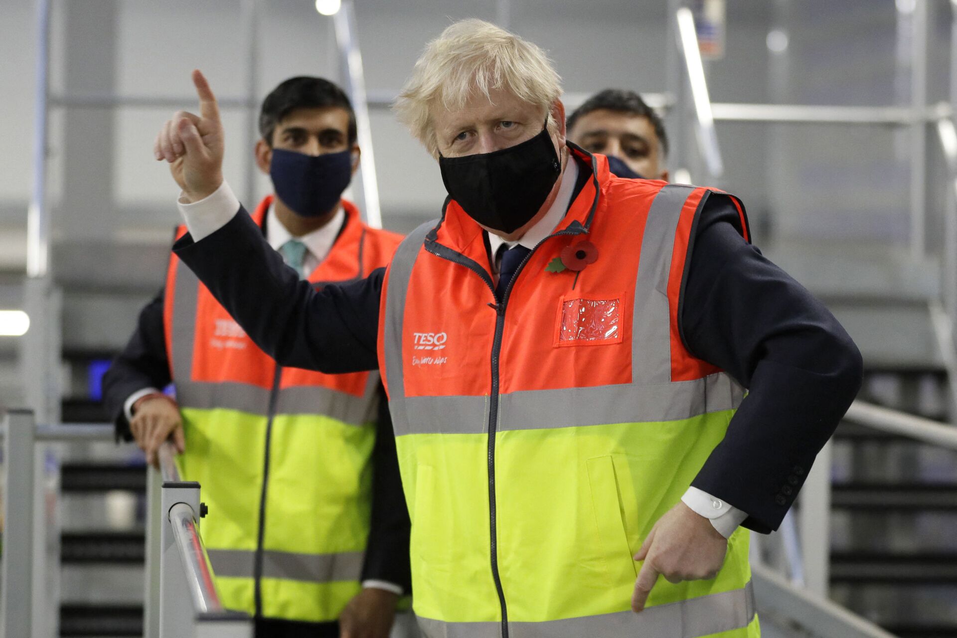 Britain's Prime Minister Boris Johnson (C) gestures during a visit to a tesco.com distribution centre in London with Britain's Chancellor of the Exchequer Rishi Sunak (L) on November 11, 2020 - Sputnik International, 1920, 07.09.2021