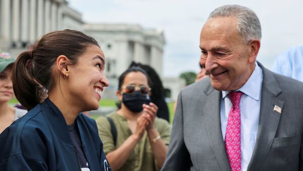 U.S. Representative Alexandria Ocasio-Cortez (D-NY) talks with U.S. Senate Majority Leader Chuck Schumer (D-NY) as they celebrate outside the U.S. Capitol Building after news that the White House intends to extend the eviction moratorium in place because of the coronavirus disease (COVID-19) pandemic, on Capitol Hill in Washington, U.S., August 3, 2021. - Sputnik International