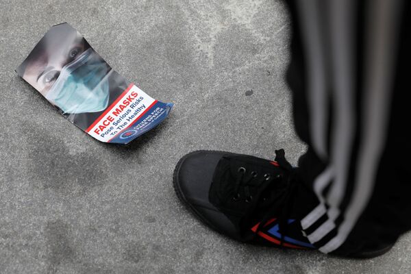 A brochure about face masks lies discarded on the ground during an anti-mandatory coronavirus disease (COVID-19) vaccine protest. - Sputnik International