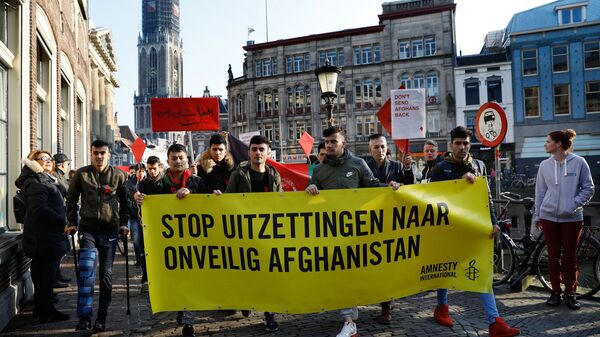 People hold a banner reading Stop the expulsions of people to unsafe Afghanistan during a march, on February 18, 2018, in the centre of Utrecht, to protest against the deportation of refugees to Afghanistan - Sputnik International
