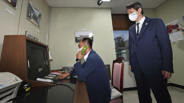 A South Korean government official makes a phone calls to North Korea via the dedicated communications hotline as South Korean Unification Minister Lee In-young, right, watches during a visit to Panmunjom in the Demilitarized Zone, South Korea, Wednesday, Sept. 16, 2020 - Sputnik International