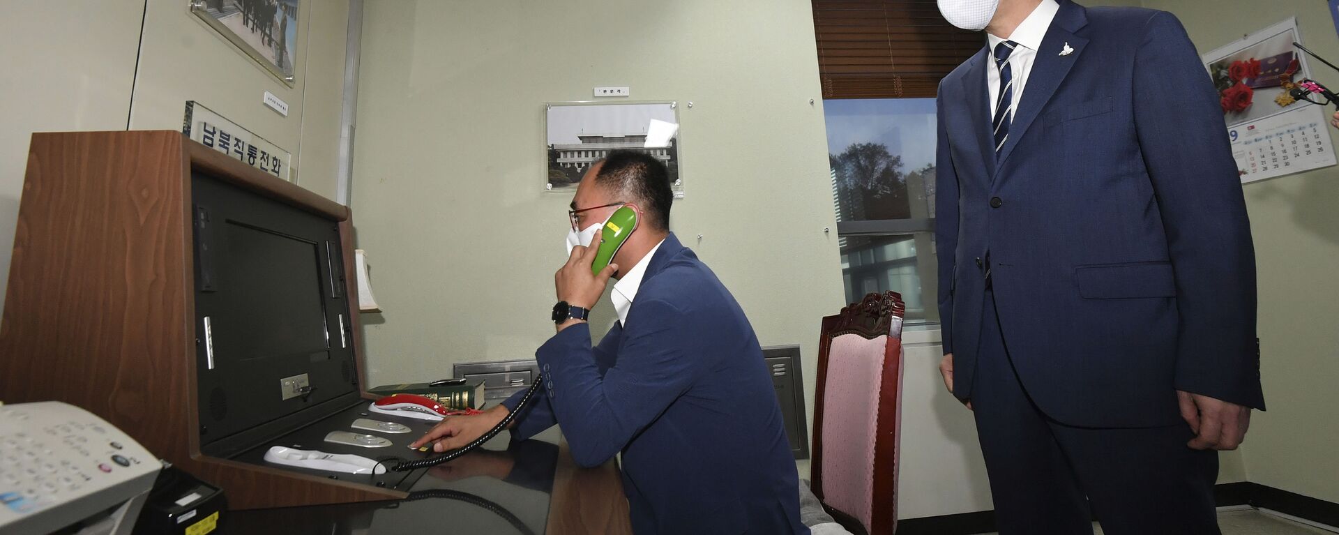 A South Korean government official makes a phone calls to North Korea via the dedicated communications hotline as South Korean Unification Minister Lee In-young, right, watches during a visit to Panmunjom in the Demilitarized Zone, South Korea, Wednesday, Sept. 16, 2020 - Sputnik International, 1920, 29.09.2021