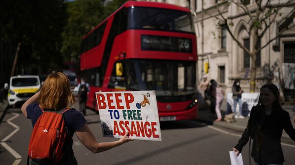 A supporter of WikiLeaks founder Julian Assange holds a placard as they protest, during the first hearing in the Julian Assange extradition appeal, at the High Court in London, Wednesday, Aug. 11, 2021. - Sputnik International
