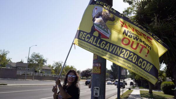 A supporter of the California recall of Gov. Gavin Newsom holds a sign outside of a debate by Republican gubernatorial candidates at the Richard Nixon Presidential Library Wednesday, Aug. 4, 2021, in Yorba Linda, Calif. Newsom faces a Sept. 14 recall election that could remove him from office. - Sputnik International
