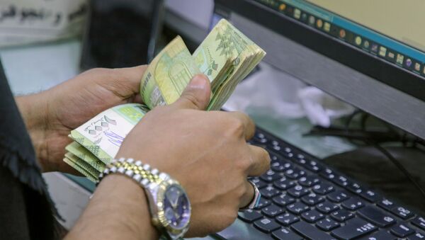 A cashier counts Yemeni riyal banknotes at a local currency exchange in Aden, Yemen June 29, 2021. Picture taken June 29, 2021. - Sputnik International