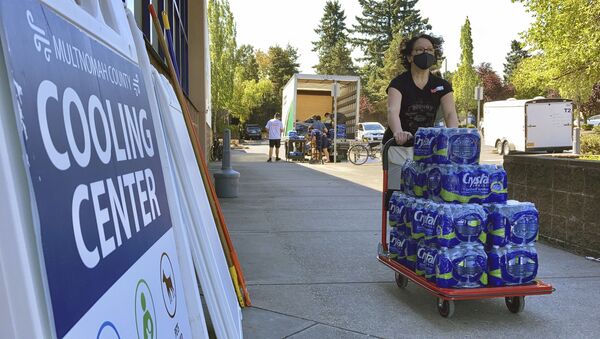 A volunteer helps set up snacks at a cooling center established to help vulnerable residents ride out the second dangerous heat wave to grip the Pacific Northwest this summer, on Wednesday, Aug. 11, 2021. - Sputnik International