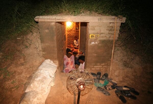 Indian border villagers take shelter in an Indian army bunker during alleged firing from the Pakistan side of the Line of Control during ongoing clashes in Abdullian village, some 37km from Jammu, on 24 August 2014. - Sputnik International