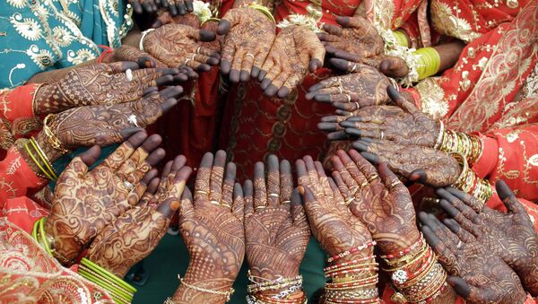 Brides show henna art on their palms as they pose for photographs during a Muslim mass marriage in Ahmadabad, India on Sunday, 21 March 2010. - Sputnik International