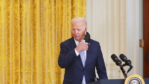 US President Joe Biden takes off his mask as he arrivers to  speak on prescription drug prices in the East Room of the White House in Washington, DC on August 12, 2021.  - Sputnik International