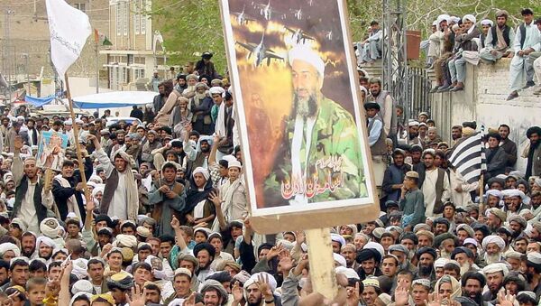 A protester raises US most wanted Osama bin Laden, Chief of al-Qaeda network portrait during an-anti US demonstration organised by a six Islamic parties alliance Muttahida Majlis-i-Amal (MMA) against the US-led forces military strike on Iraq, in southern city of Chaman close to the Afghanistan border, 21 March 2003.  - Sputnik International