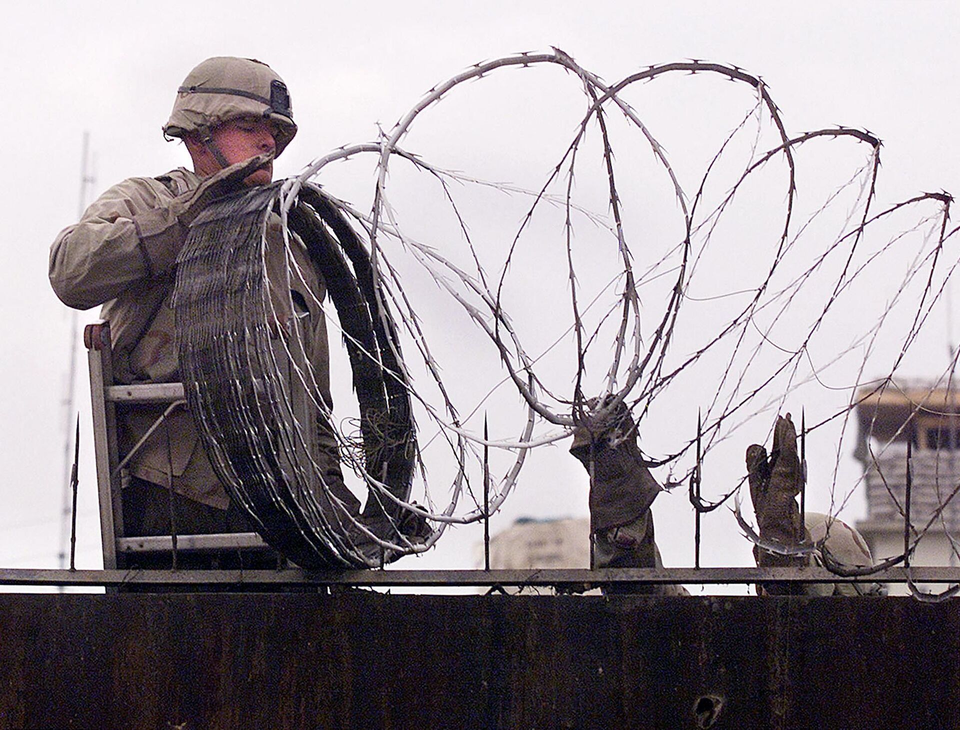  In this file photo a US Marine is given a hand using barbed wire to secure the walls the US embassy in Kabul on January 11, 2002. - The United States said on August 12, 2021 it was sending troops to the international airport in Afghanistan's capital Kabul to pull out US embassy staff as the Taliban makes rapid gains.We are further reducing our civilian footprint in Kabul in light of the evolving security situation, State Department spokesman Ned Price told reporters.This president prioritizes above all else the safety and security of Americans who are serving overseas, he said of Joe Biden, who has ordered a withdrawal of US troops from Afghanistan after nearly 20 years. - Sputnik International, 1920, 07.09.2021