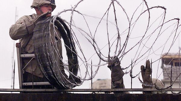  In this file photo a US Marine is given a hand using barbed wire to secure the walls the US embassy in Kabul on January 11, 2002. - The United States said on August 12, 2021 it was sending troops to the international airport in Afghanistan's capital Kabul to pull out US embassy staff as the Taliban makes rapid gains.We are further reducing our civilian footprint in Kabul in light of the evolving security situation, State Department spokesman Ned Price told reporters.This president prioritizes above all else the safety and security of Americans who are serving overseas, he said of Joe Biden, who has ordered a withdrawal of US troops from Afghanistan after nearly 20 years. - Sputnik International