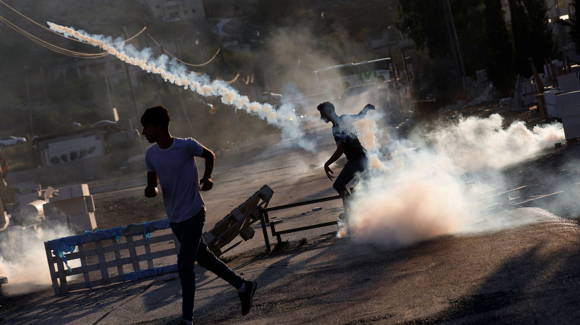 Palestinian protester throws back a tear gas grenade during a protest over the killing of a Palestinian man by Israeli soldiers, according to health ministry, in Beita in the Israeli-occupied West Bank July 28, 2021 - Sputnik International, 1920, 12.11.2021