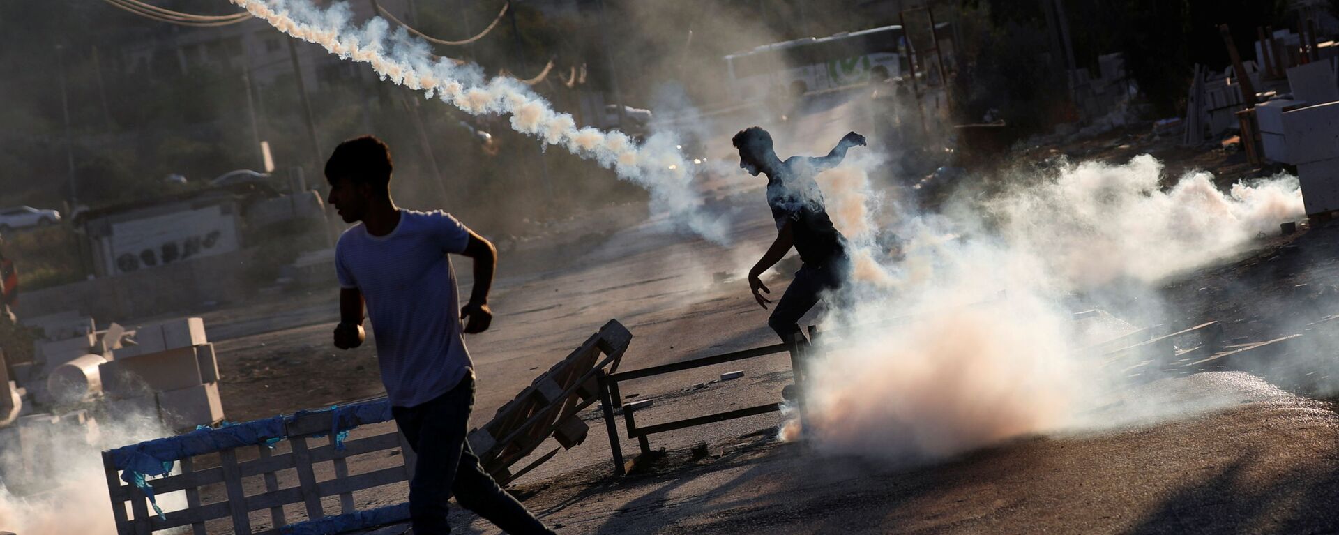 Palestinian protester throws back a tear gas grenade during a protest over the killing of a Palestinian man by Israeli soldiers, according to health ministry, in Beita in the Israeli-occupied West Bank July 28, 2021 - Sputnik International, 1920, 15.08.2021