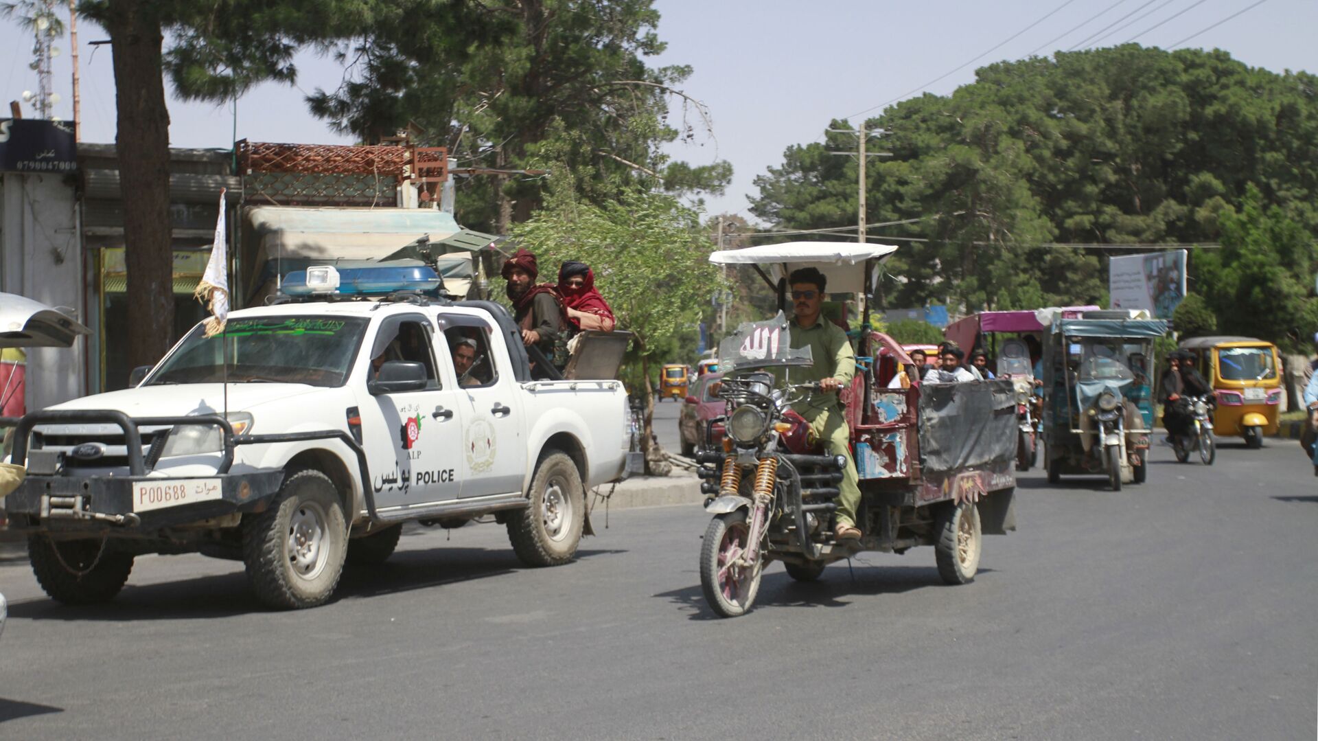 Members of the Taliban, left, drive with other motorists through city of Herat, Afghanistan, west of Kabul, Saturday, Aug. 14, 2021, after the province was taken from the Afghan government. (AP Photo/Hamed Sarfarazi) - Sputnik International, 1920, 07.09.2021