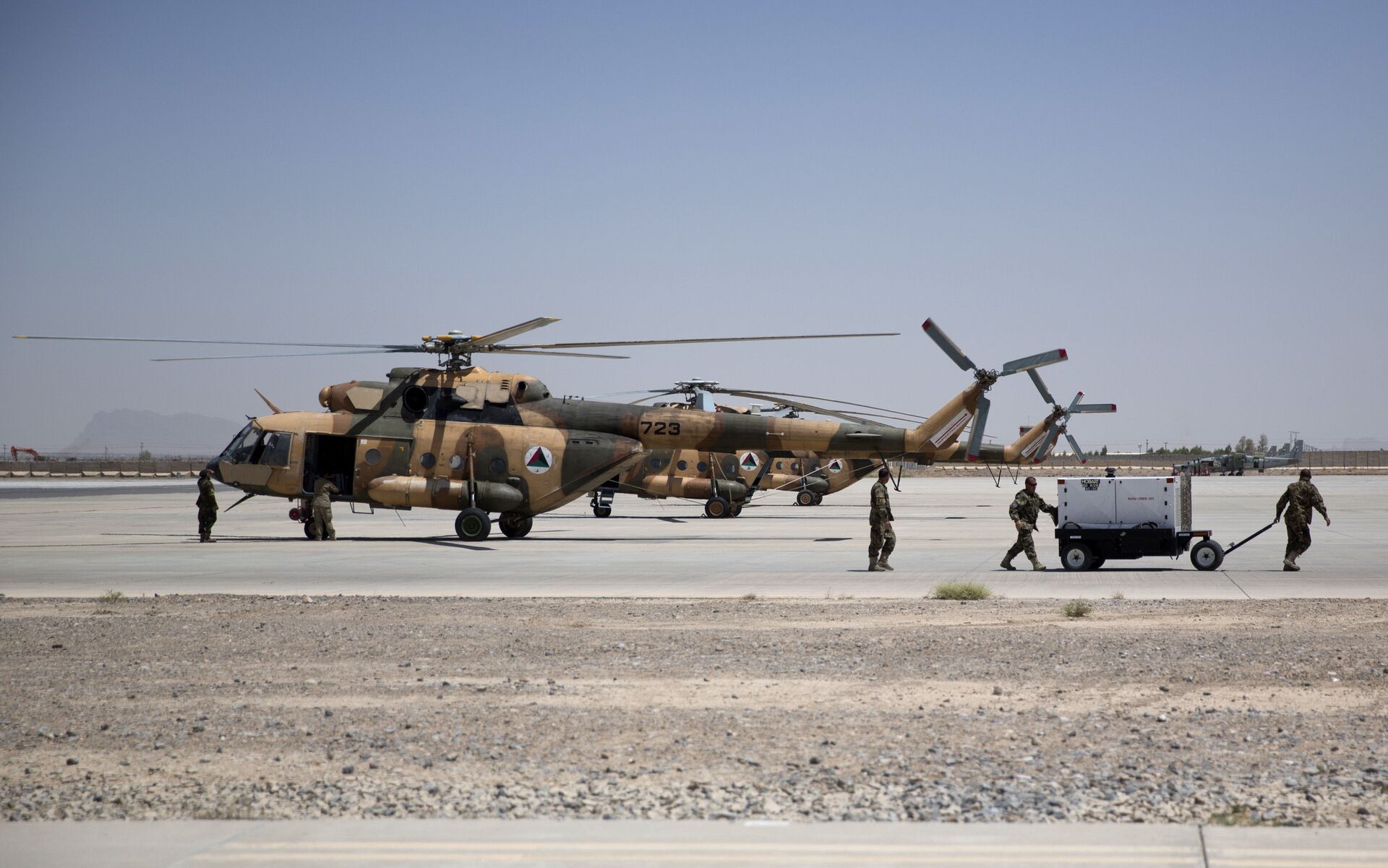 Members of Afghanistan's National Army work near military helicopters, in Kandahar Air Field, Afghanistan, Tuesday, Aug. 18, 2015. Since the departure from Afghanistan last year of most international combat troops, Afghan security forces have been fighting the insurgency alone. Figures show that casualty rates are extremely high, reflecting an emboldened Taliban testing the commitment and strength of the Afghan military. (AP Photo/Massoud Hossaini) - Sputnik International, 1920, 19.01.2022