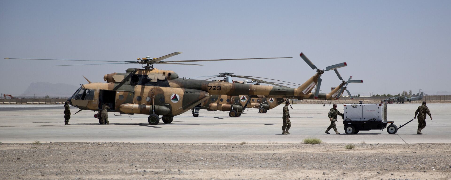 Members of Afghanistan's National Army work near military helicopters, in Kandahar Air Field, Afghanistan, Tuesday, Aug. 18, 2015. Since the departure from Afghanistan last year of most international combat troops, Afghan security forces have been fighting the insurgency alone. Figures show that casualty rates are extremely high, reflecting an emboldened Taliban testing the commitment and strength of the Afghan military. (AP Photo/Massoud Hossaini) - Sputnik International, 1920, 15.08.2021