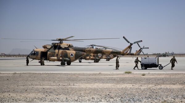 Members of Afghanistan's National Army work near military helicopters, in Kandahar Air Field, Afghanistan, Tuesday, Aug. 18, 2015. Since the departure from Afghanistan last year of most international combat troops, Afghan security forces have been fighting the insurgency alone. Figures show that casualty rates are extremely high, reflecting an emboldened Taliban testing the commitment and strength of the Afghan military. (AP Photo/Massoud Hossaini) - Sputnik International