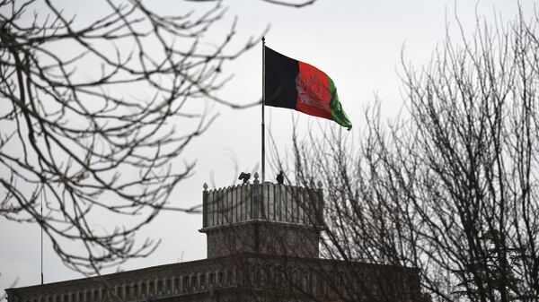 An Afghan security personnel keeps watch on a tower as the Afghan national flag flutters ahead of the start of Afghanistan President Ashraf Ghani's swearing-in inauguration ceremony, at the Presidential Palace in Kabul on March 9, 2020. - Sputnik International