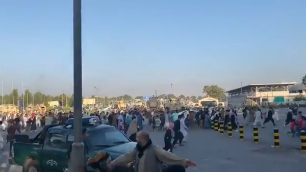 Screenshot from a video allegedly showing a crowd of people rushing to the Kabul international airport as gunshots are heard - Sputnik International