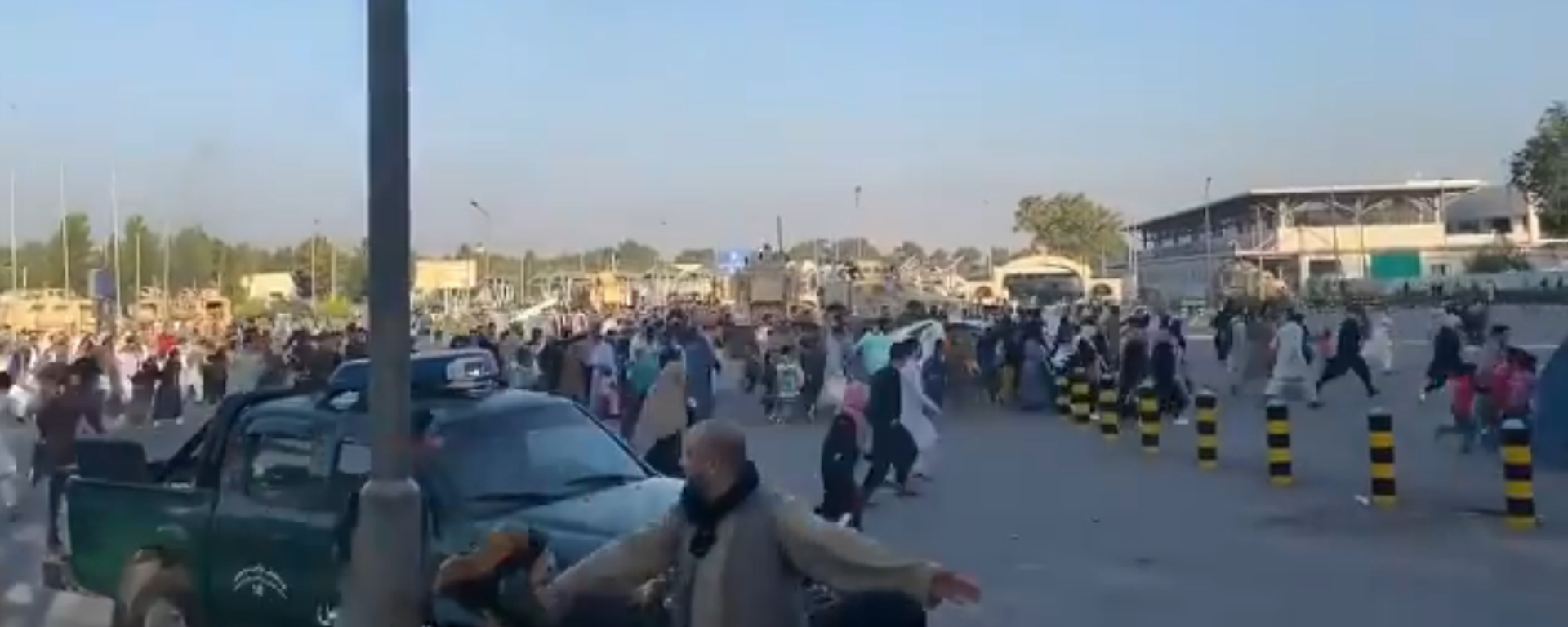 Screenshot from a video allegedly showing a crowd of people rushing to the Kabul international airport as gunshots are heard - Sputnik International, 1920