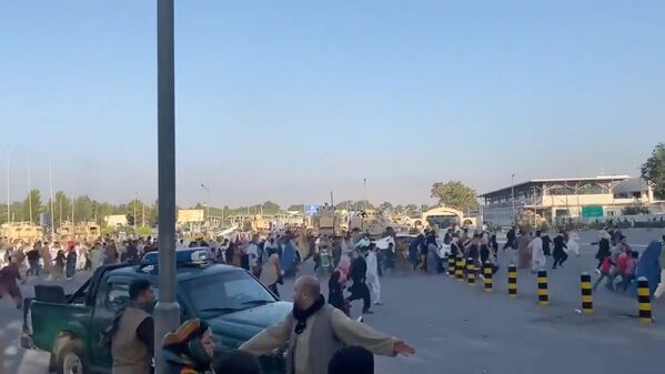 A mass of people run towards a Kabul Airport Terminal after Taliban insurgents took control of the presidential palace in Kabul, 16 August 2021, in this still image taken from video obtained from social media. - Sputnik International